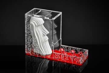 tower for throwing dice with a white idol on a black background with reflection