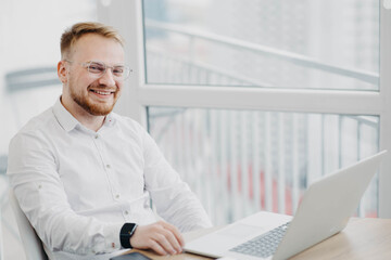 Caucasian blond hair man working with laptop in office