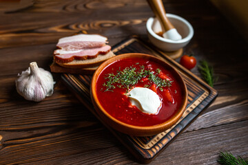 Traditional Ukrainian borsht, red vegetable and meat soup or borscht with smetana on wooden...