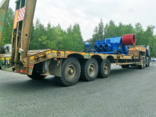 Obraz premium A truck is transporting drilling equipment. Compressor for the drilling and oil and gas industry. Oversized cargo transportation. Fresh paint on the equipment