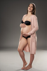 Pregnant woman in lingerie and robe