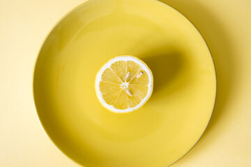 Half lemon fruit on yellow plate