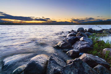 sunset over the sea. stones in the water. long exposure lake