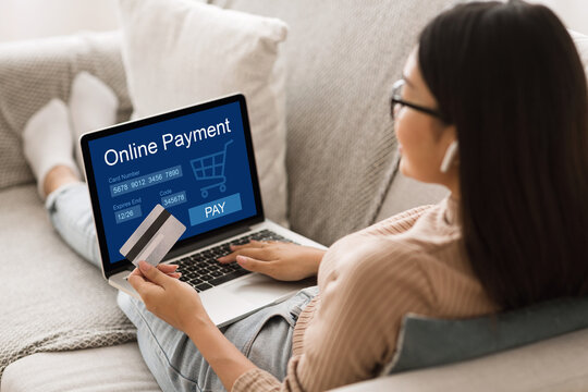 Asian woman using laptop and credit card, online payment concept
