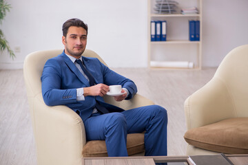 Young male employee waiting for business meeting