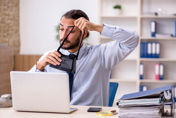 Obraz premium Young male employee wearing virtual glasses at workplace