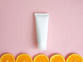 Mock-up of cosmetic bottle for branding and label. Orange slices border and mockup or 3d model of white squeeze bottle plastic tube. Spa cosmetic product.