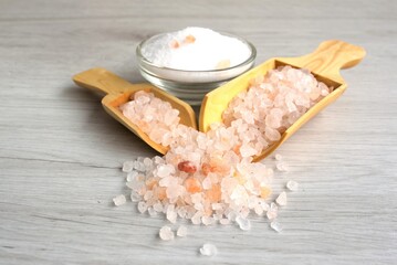 
Colorful rock salt in wooden spoon on a white background