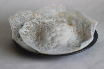 Laced Rice Crepes or Fermented rice pancakes made with fermented rice batter and coconut milk.