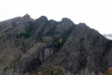Mountains covered with snow with rocks at the top.
