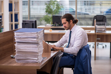 Young male employee unhappy with excessive work in the office