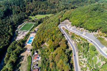 Fototapeta na wymiar Winding road serpentine from a high mountain pass in the rhine village Bendorf Sayn Germany Aerial view