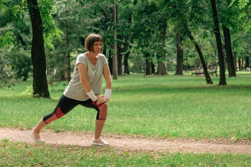 Female jogger stretching muscles and warming up for running exercise in park