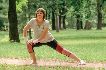 Female jogger stretching muscles and warming up for running exercise in park