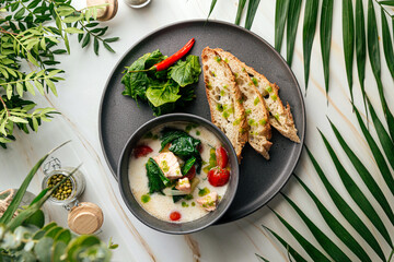 Creamy soup with salmon spinach and crispy french baguette