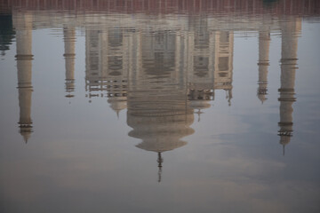 The reflection of the world famous Taj Mahal in the river Yamuna. Normal perspective. Day. Overcast sky. Due to the slight movement of the river, the image is somewhat blurred. 