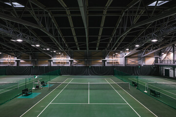 Fototapeta na wymiar Empty green tennis courts under roof. Nobody. Top view.