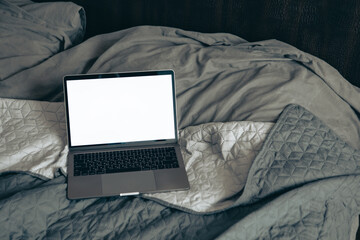 laptop on the bed with white screen