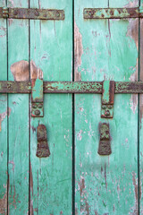old iron, rusty latch on the green wooden door