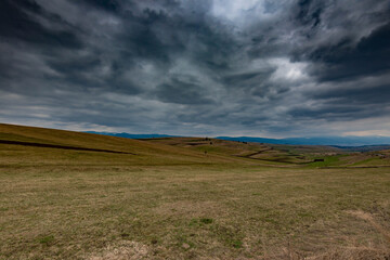 Gathering dramatic stormclouds over the green valley at early spring in Transylvania.