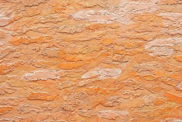 Plaster on a orange wall. Concrete wall texture close up.