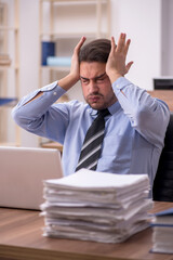 Young male employee and too much work in the office
