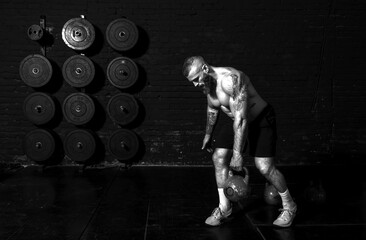 Young active strong sweaty fit muscular man with big muscles doing back muscles workout with...