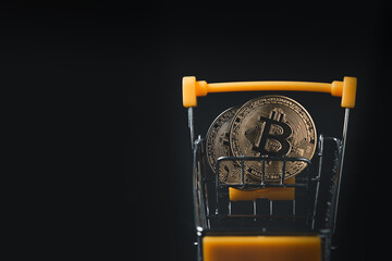 bit coin in yellow trolley on black background, electronic virtual money for web banking