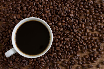  Coffee cup and coffee beans roasted on wooden background,Top view,copy space.