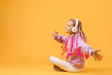 Back view of Adorable child in rounded glasses with pink dreadlo