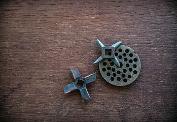 Rusty metal knives for electric meat grinder on a wooden background