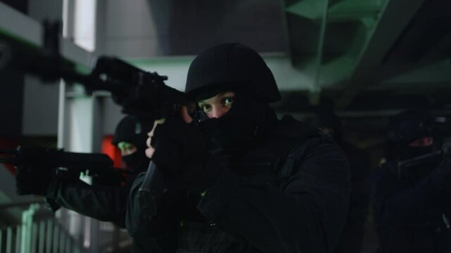 Anti terrorist squad in masks walking on steel bridge with sniping rifles