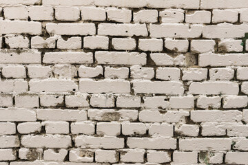 An old white painted brick wall Background with uneven bricks and red spots mid range 