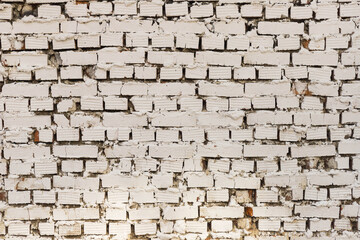 An old white painted brick wall with uneven bricks and red spots Background