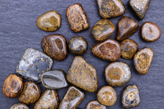 Bronzite heap up jewel stones texture on black stone background