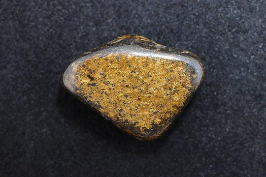 Bronzite jewel stone texture on black background. Macro closeup.