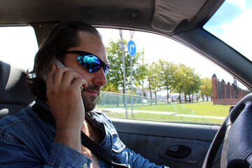 man driving a car and talking on the phone