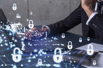 A programmer is typing a code on computer to protect a cyber security from hacker attacks and save clients confidential data. Padlock Hologram icons over the typing hands. Formal wear.