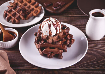 Homemade chocolate waffles with ice cream decorated chocolate syrup.
