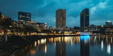 Artistic perspective of the Singapore River atmosphere at night with long exposure and a teal sky and orange lights