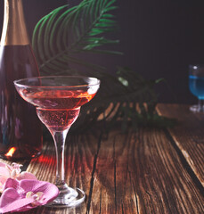 Summer tropical pink cocktail decorated orchid flower on the wooden background