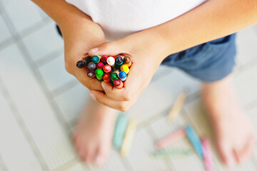 Close-up of child's hands with lots of colorful wax crayons pencils. Kid preparing school and nursery equipment and student stuff. Back to school. Education, school, learning concept