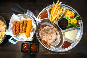 Pork steak with fries and vegetables on the food tray