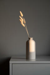 Dried fluffy flowers in ceramic vase on table. Minimal interior floral decor, nordic, Scandinavian style. © photoguns