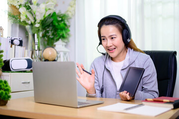 Asian businesswoman online working at home. Thai woman lifestyle in living room. Social distancing...