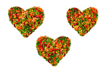 Heart made of vegetables. Corn, carrot, bell pepper, green beans. Isolated on white.