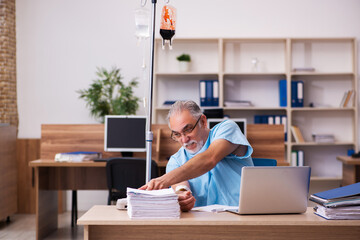 Old male employee in blood transfusion concept