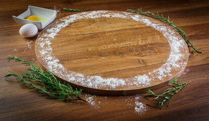 Wooden pizza pan, wrapped in wheat, eggs and rosemary.