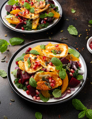 Fried Halloumi Cheese salad with beetroot, orange, pomegranate and pumpkin seeds, red onion, green vegetables. healthy food