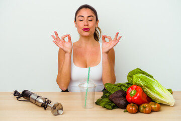 Young caucasian woman preparing a healthy smoothie with vegetables